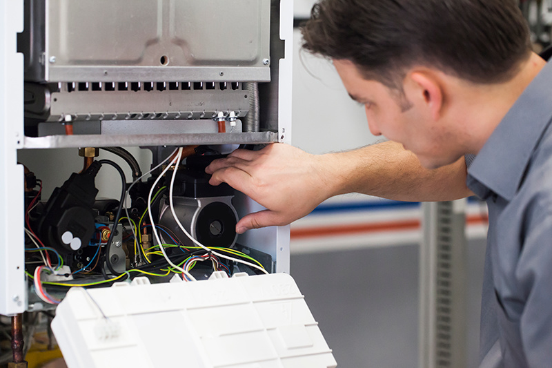 an HVAC technician performing maintenance on a heat pump.