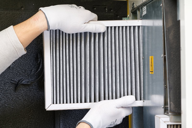 Kodiak Heating & Cooling technician replacing air filter in Indian Trail, NC, home.